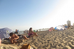 Gente tomando sol en la playa a solo pasos del departamento